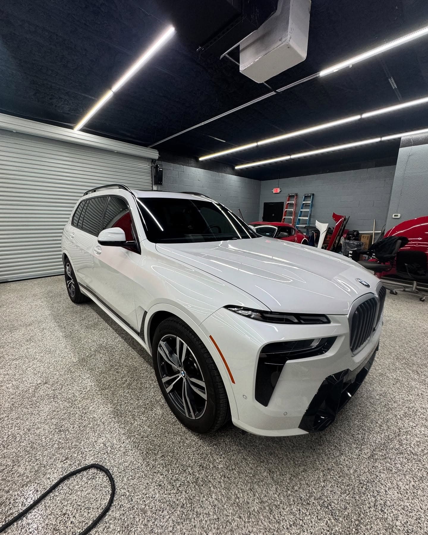White BMW X7 with tinted windows in the install bay