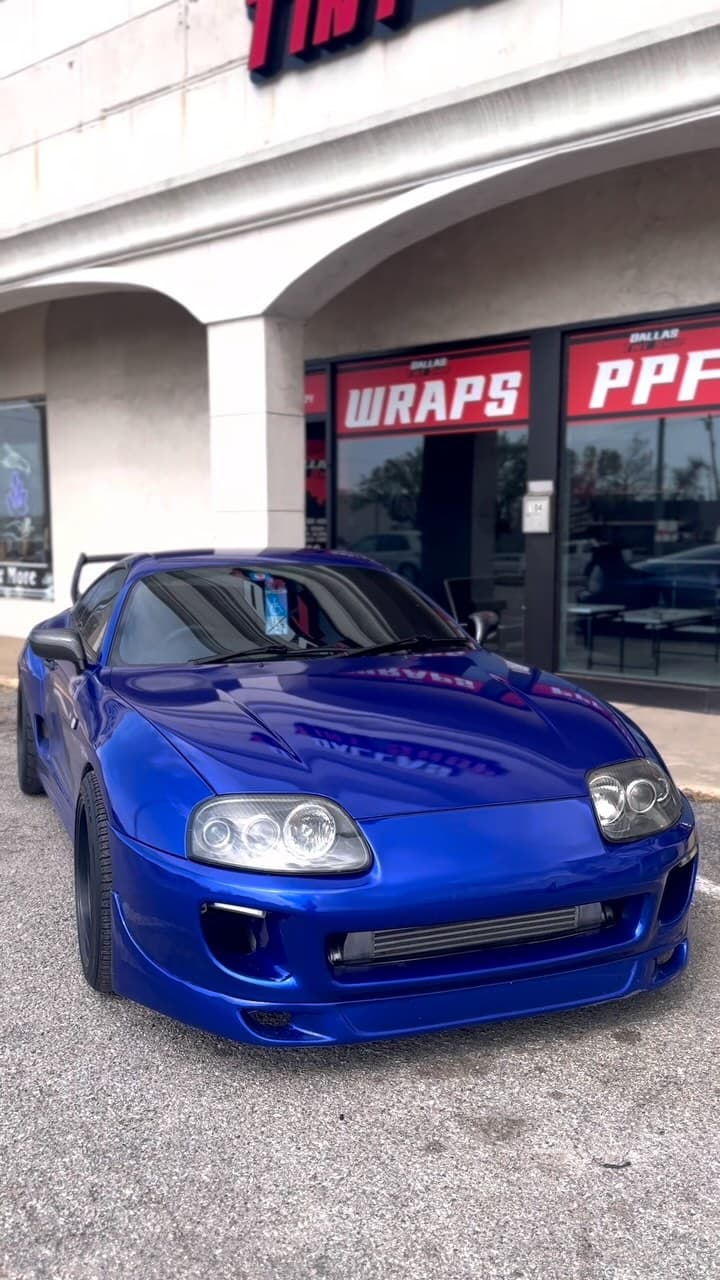 Blue Toyota Supra after ceramic coating, parked outside the Dallas Tint Shop storefront